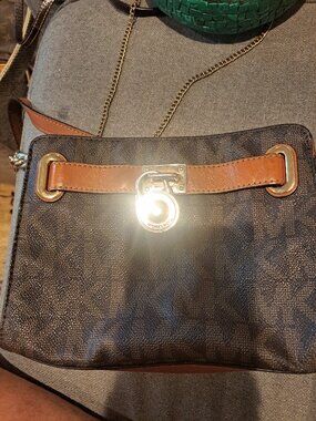 Classic Michael Kors crossbody bag with signature MK monogram print in brown. Th